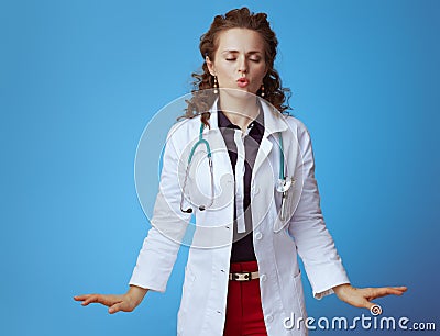Elegant medical doctor woman calming down on blue Stock Photo