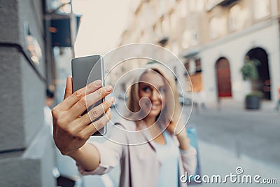 Smiling lady with shopping bags making selfie on the street Stock Photo