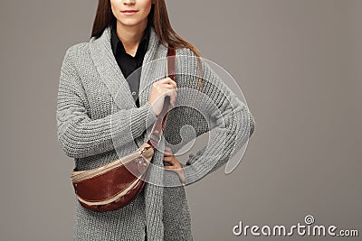 Elegant model in gray woven cardigan with a leather fanny pack Stock Photo