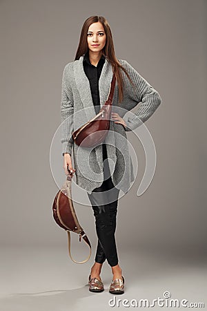 Elegant model in gray woven cardigan with two leather fanny pack Stock Photo