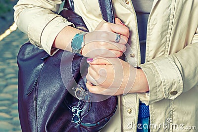 Elegant outfit. Closeup of brown leather bag handbag in hand of stylish woman. Fashionable girl in the street. Casual Stock Photo