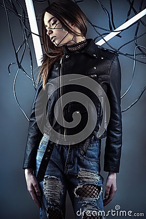 Elegant robot girl in wires in style cyberpunk in leather jacket and ripped jeans Stock Photo