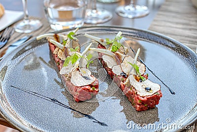 Elegant seasoned beef tartare with black truffles and artichoke. Gourmet Delicatessen Stock Photo