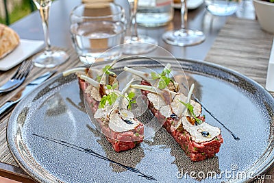 Elegant seasoned beef tartare with black truffles and artichoke. Gourmet Delicatessen Stock Photo