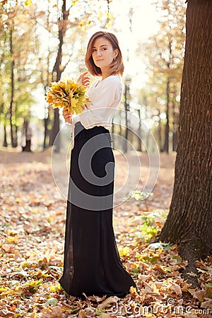 Elegant slim young girl in autumn park Stock Photo