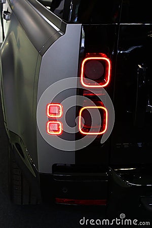 Elegant smooth square shaped LED rear light on new model of british off-road SUV car Land Rover Defender, displayed on car expo Editorial Stock Photo