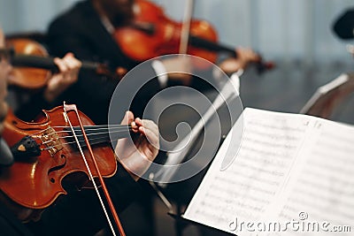 Elegant string quartet performing at wedding reception in restaurant, handsome man in suits playing violin and cello at theatre Stock Photo