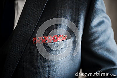 Elegant and stylish close up of silk pocket accessory handkerchief in Burgundy red with blue pattern tucked wedding suit jacket Stock Photo