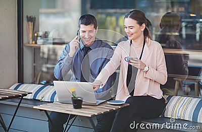 Elegant two young business people having an informal coffee meeting - Happy couple sitting on a cafe terrace flirting Stock Photo