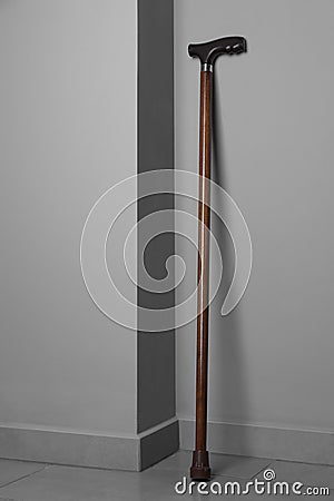 Elegant walking cane near light grey wall indoors Stock Photo