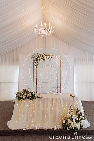 Elegant wedding table in a tent with chandelier and flowers Stock Photo