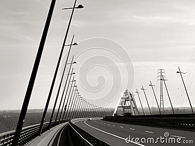 Elegant white steel arched bridge and highway with tilted street lights Stock Photo