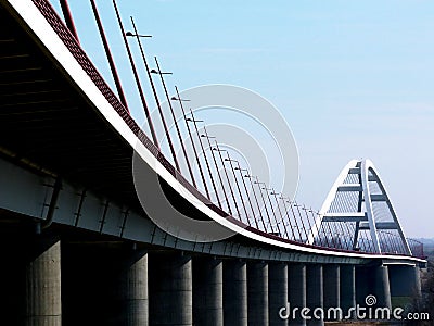 Elegant white steel arched bridge with tilted street lights Stock Photo