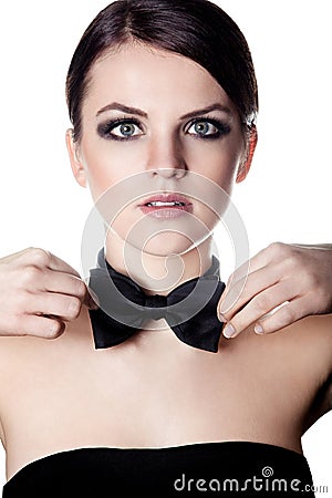 Elegant woman adjusting bow tie Stock Photo