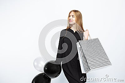 Elegant woman in black dress and with red lips, holding shopping Stock Photo