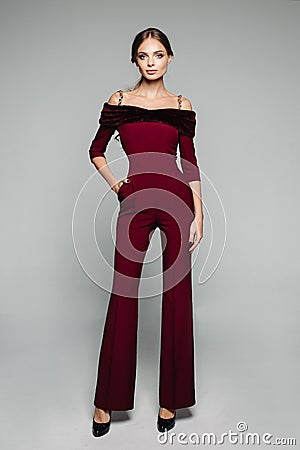 Elegant woman in bordo overall with bare shoulders and high heels. Stock Photo