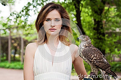 Elegant woman brunette with hawk bird outdoor portrait Stock Photo