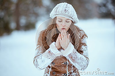 elegant woman warming cold hands with breath Stock Photo