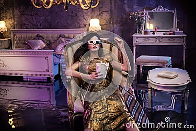 Elegant woman watching a movie in a conceptual flooded bedroom Stock Photo