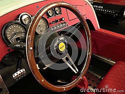 Elegant wooden steering wheel and vintage red dashboard of Vanderhall Venice Speedster, three-wheeled hand made autocycle. Editorial Stock Photo