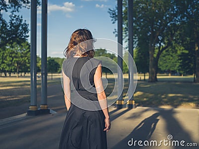 Elegant young woman in park at sunset Stock Photo