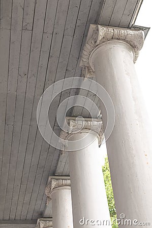 Element of an old column against a wood ceiling. Vintage element of building art. The element of the white column under the Stock Photo