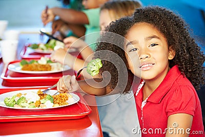 Elementary Pupils Enjoying Healthy Lunch In Cafeteria Stock Photo