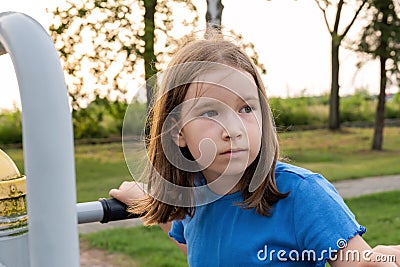 Elementary school age child on a playground outdoors, simple natural serious portrait face closeup Caucasian European Polish girl Stock Photo