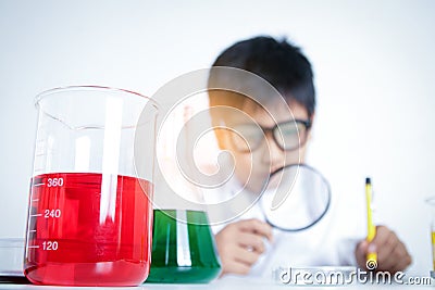 Elementary boy wearing white clothes, doing scientific experiments Stock Photo