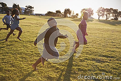 Elementary school boys and girls running in an open field Stock Photo