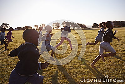 Elementary school boys and girls running in an open field Stock Photo