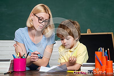 Elementary school - education and learning child concept. Teacher helping young boy with lesson. Great study achievement Stock Photo