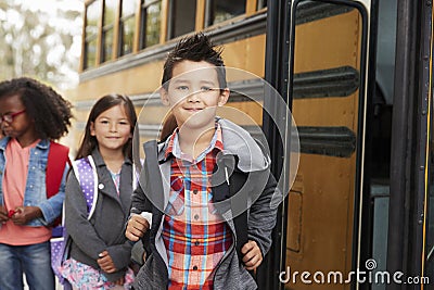 Elementary school kids queueing for the school bus Stock Photo