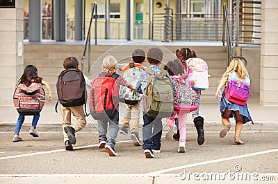 Elementary school kids running into school, back view Stock Photo