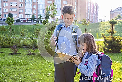 Elementary school students with a textbook outdoors. Back to school Stock Photo