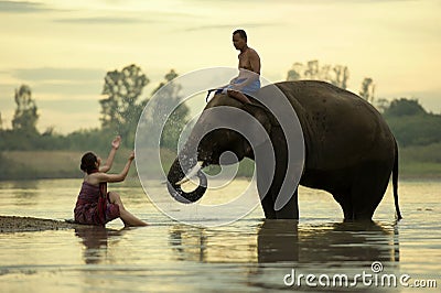 Elephant Mahout women and men are taking a bath in the river during the sunset Editorial Stock Photo