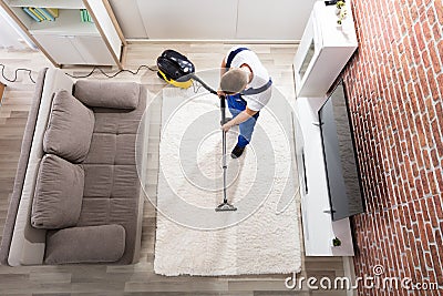 Janitor Cleaning Carpet With Vacuum Cleaner Stock Photo