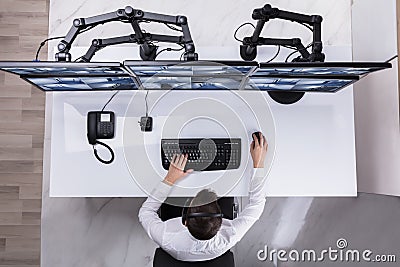 Security Guard Monitoring Multiple Camera Footage On Computer Stock Photo