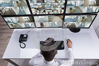 Security Guard Monitoring Multiple Camera Footage On Computer Stock Photo