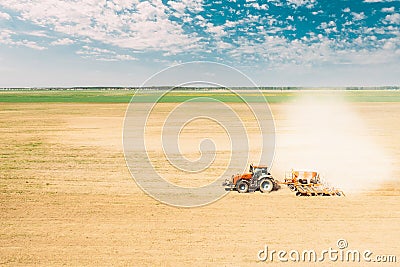 Elevated View Tractor With Seed Drill Machine Sowing Seeds For Crops In Spring Season. Beginning Of Agricultural Spring Stock Photo