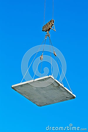 Elevating crane lifting a concrete plate Stock Photo