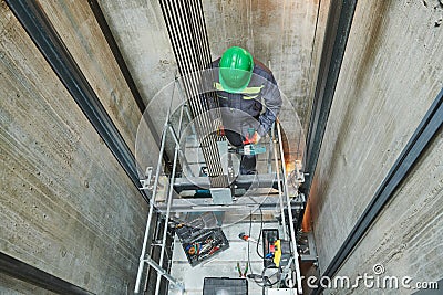 Lift machinist repairing elevator in lift shaft Stock Photo