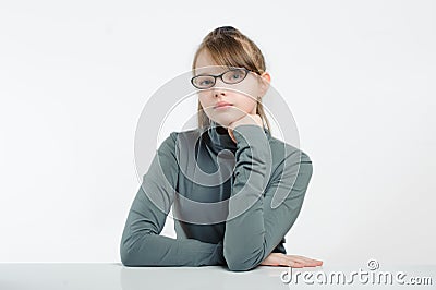 Eleven-year girl sitting at the table. Stock Photo