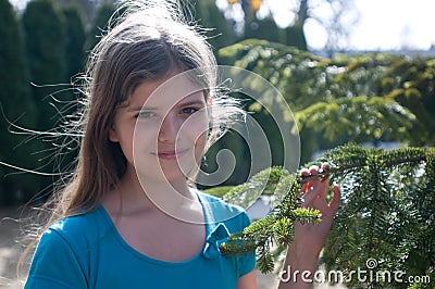 Eleven years girl with fir tree outdoor Stock Photo