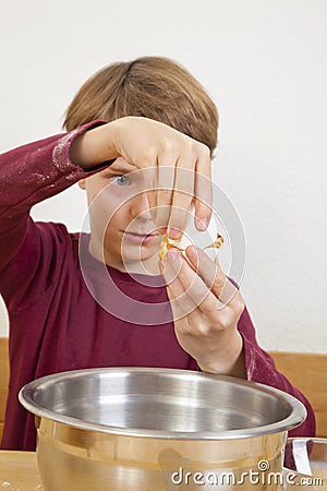 Eleven years old boy opening an egg Stock Photo