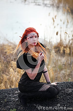 Elf women with fiery hair on nature. Stock Photo