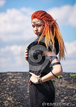 Elf women with fiery hair on nature. Stock Photo