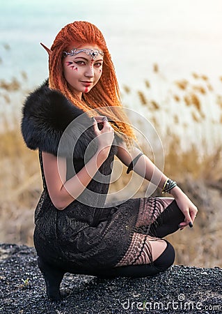 Elf women with fiery hair on nature. Stock Photo