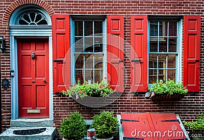 Elfreth`s Alley a historic street from colonial era in Old City, Philadelphia. House with red door and red window`s shutters. Editorial Stock Photo