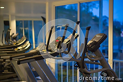 Elliptical cross trainers in a fitness gym at evening Stock Photo